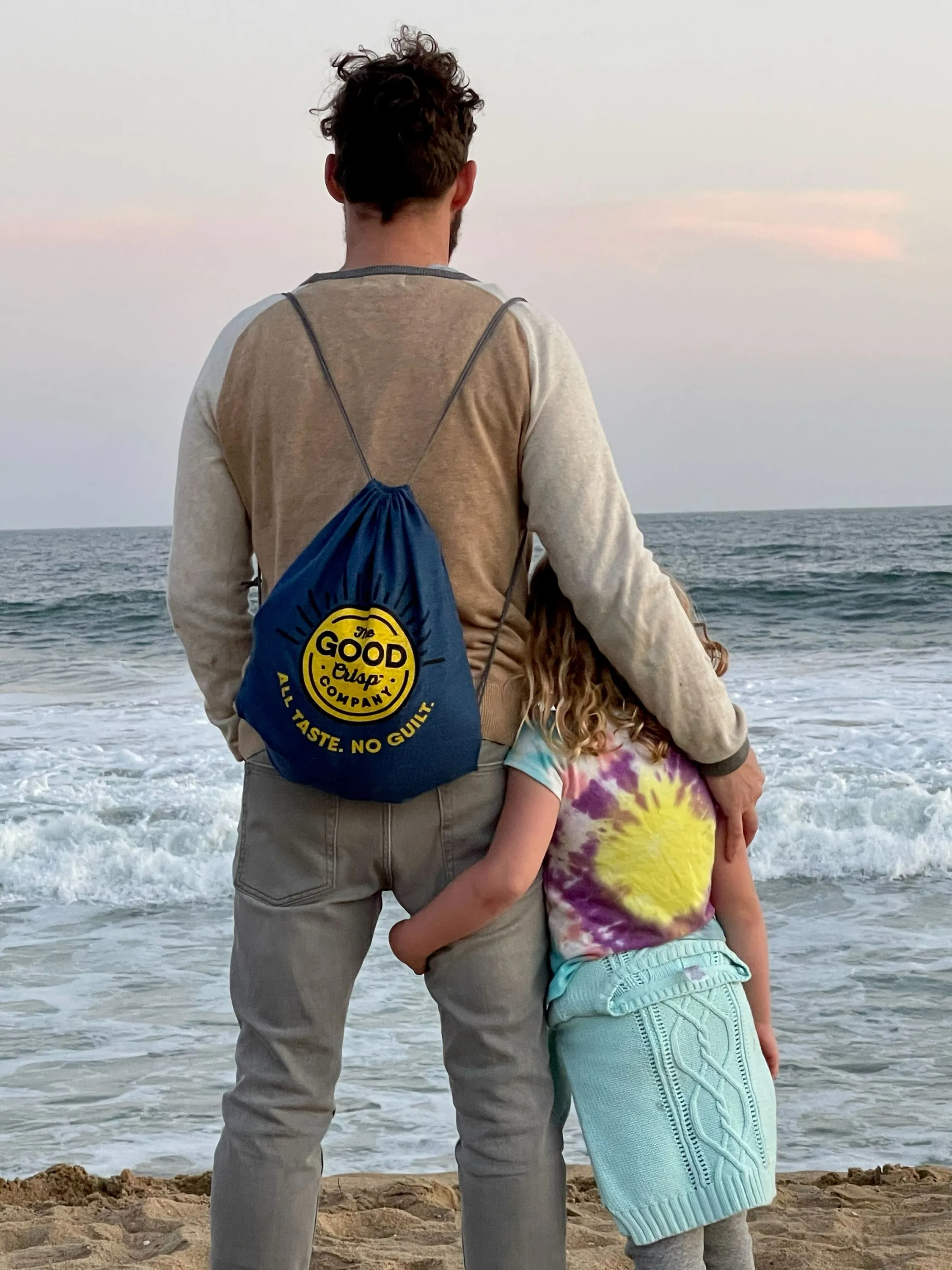 Trixie's father and sister standing arm in arm, looking out at the ocean